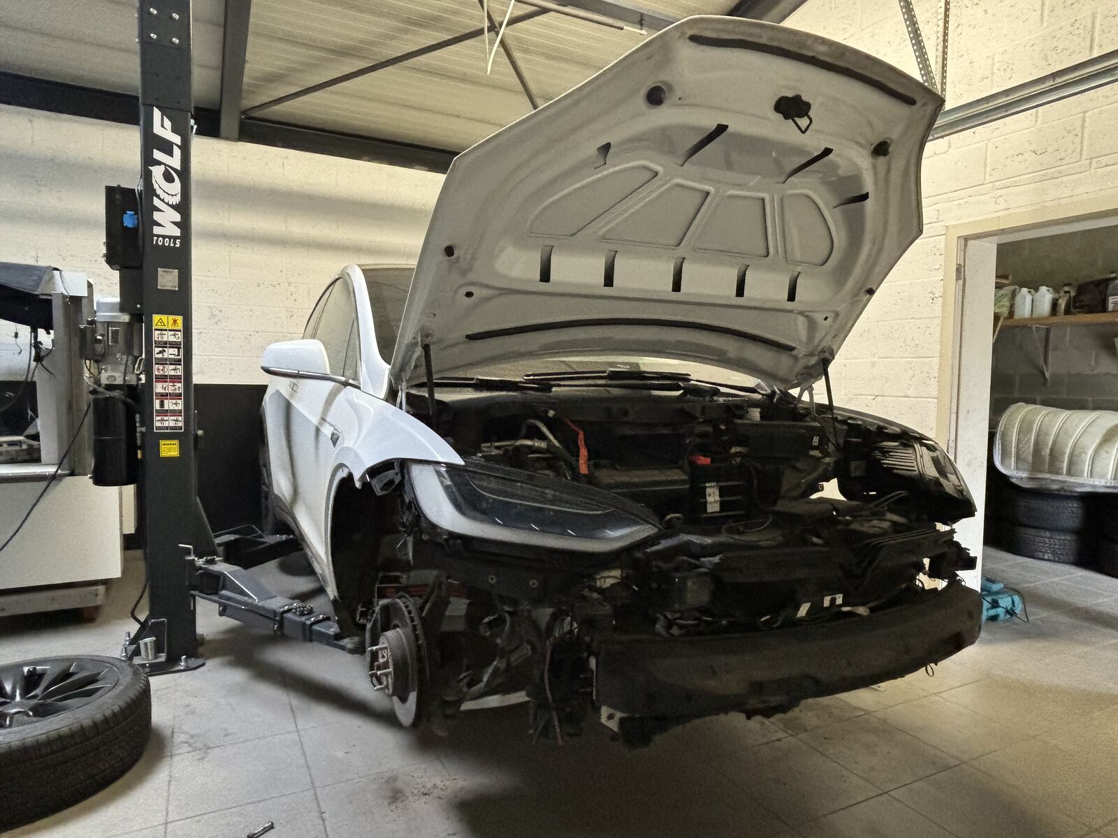 Tesla on a lift inside our EV workshop